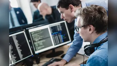 Startup business and entrepreneurship problem solving. Young AI programmers and IT software developers team brainstorming and programming on desktop computer in startup company share office space.