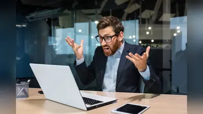 Angry and angry businessman talking on video call, talking to colleagues and shouting quarrel, mature boss working inside modern office building, senior man with laptop and beard.